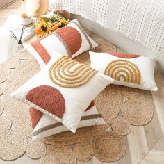 two decorative pillows sitting on top of a rug