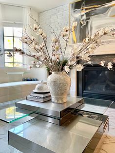 a vase filled with flowers sitting on top of a table next to a fire place