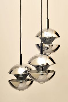 three chrome balls hanging from the ceiling in an art deco style setting with black cords