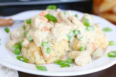 a white plate topped with chicken and rice casserole next to breadsticks