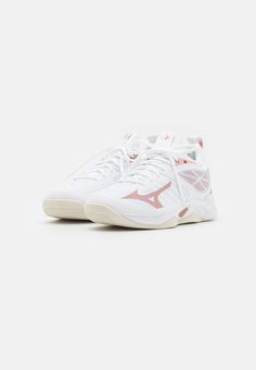 a white tennis shoe with pink accents on the sole and side laces, in front of a white background