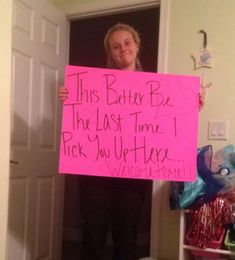 a woman holding up a pink sign that says, this battery be the last time i pick you up here