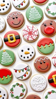 many decorated cookies are arranged on a white surface with christmas themed frosting and decorations