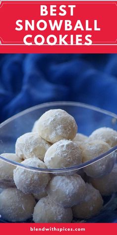 a bowl filled with snowball cookies sitting on top of a blue cloth covered table