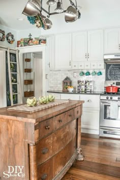 a kitchen with an island in the middle of it and lots of lights hanging from the ceiling