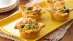 three mini quiche cups on a yellow tray with red and white striped napkins