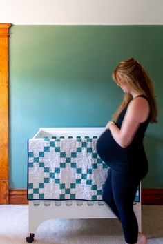 a woman standing next to a baby crib