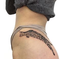 a tattoo on the back of a woman's lower body shows a cheetah