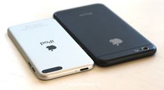 two cell phones sitting next to each other on a white table with an apple logo