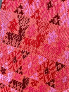 a red and pink patterned cloth with black letters on it