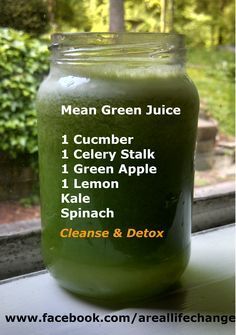 a jar filled with green juice sitting on top of a window sill