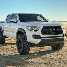 a white toyota pickup truck parked in the desert