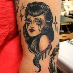 a woman's arm with an old school tattoo design on the left side of her body