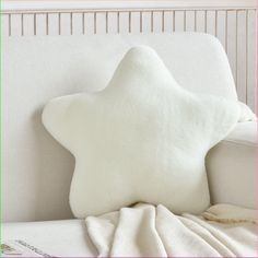 a white star pillow sitting on top of a bed