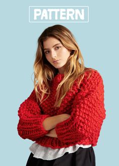 a woman wearing a red sweater with her arms crossed