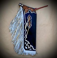 a blue and white bag with tassels hanging from it's side on a wall