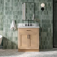 a bathroom with green tiles and a white bathtub