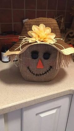 a scarecrow hat with a yellow flower on it sitting on top of a counter