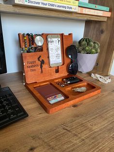 a desk with a keyboard, phone and other personal items on top of the desk