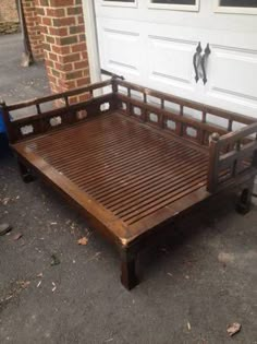 a wooden bed frame sitting in front of a garage door