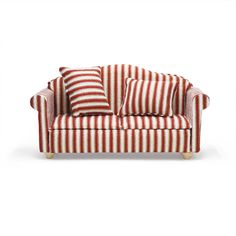 a red and white striped couch sitting on top of a white floor next to pillows