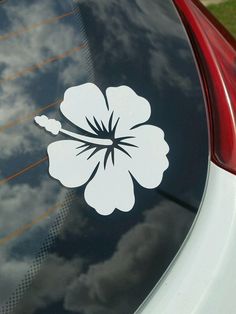 a white flower sticker is on the back of a car's tail window