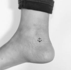 a small anchor tattoo on the ankle is shown in black and white, as well as an arrow