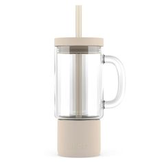 a glass and plastic blender with a straw in the top, on a white background