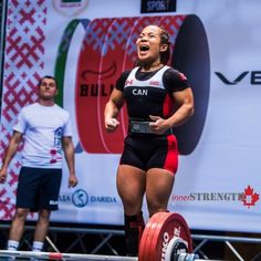 a woman standing on top of a barbell with her mouth open