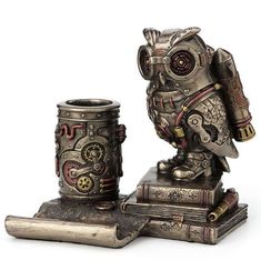 an owl figurine sitting on top of a stack of books next to a cup