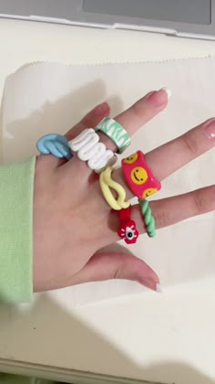 a person's hand with rings on it sitting next to a laptop computer keyboard