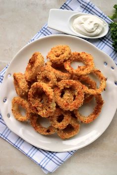 fried onion rings on a plate with ranch dip and broccoli in the background