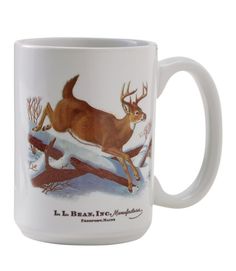 a white coffee mug with an image of a deer leaping over a log in the snow