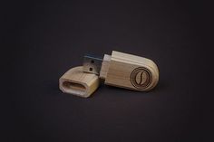 a wooden usb stick with the letter o on it's side sitting on a black surface