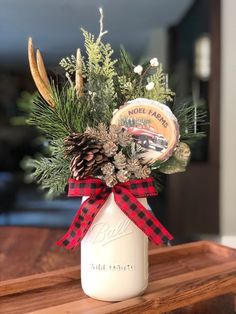 a mason jar filled with pine cones and greenery