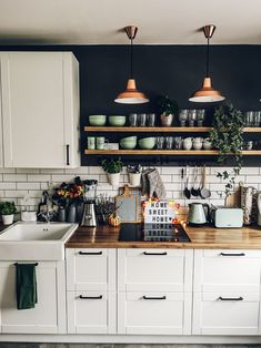 a kitchen with white cabinets and wooden counter tops