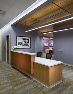 an empty office with purple walls and wooden desks