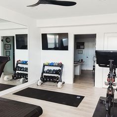 there is a gym with exercise equipment in the room, and mirrors on the wall