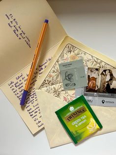 an envelope with two photos and a pencil on it next to some other items from the same era