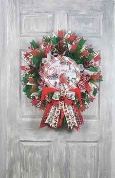 a christmas wreath on the front door decorated with candy canes, holly and mist