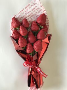 a bunch of chocolate covered strawberries wrapped in red paper