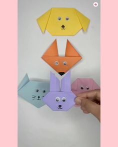 three origami cats and a dog with their faces cut out to look like they are