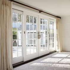 an empty room with white doors and windows