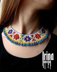 a woman wearing a multicolored beaded necklace with flowers and leaves on it