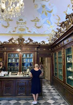 a woman in a blue dress standing at a counter