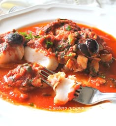 a white plate topped with fish covered in sauce