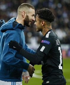 two men standing next to each other on a soccer field