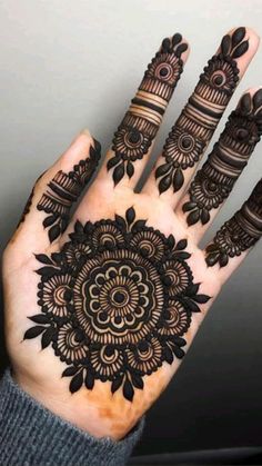 the hand is decorated with black henna