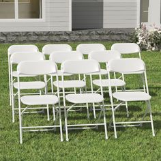 rows of white folding chairs sitting in the grass