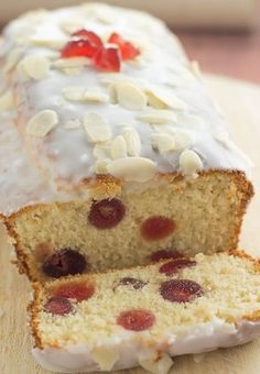 a loaf of cake with white frosting and fruit toppings